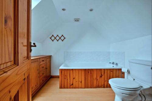 a bathroom with a toilet and a bath tub at Lochead Cottage Ellary in Lochgilphead