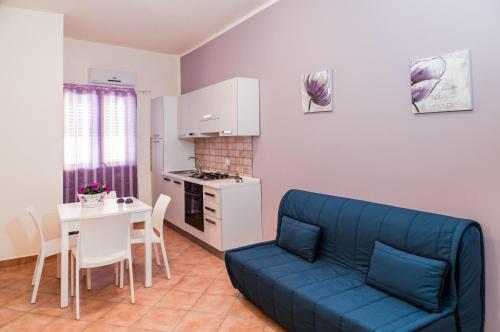 sala de estar con sofá azul y mesa en Casa vacanze Biondo, en Trappeto