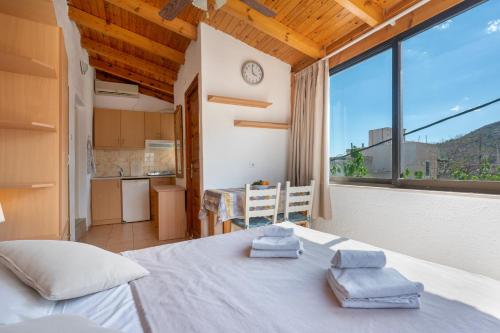 a bedroom with a large white bed and a kitchen at Nikos House in Ierapetra