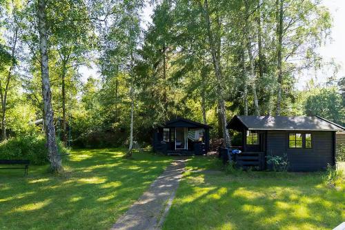 a small cabin in the middle of a yard at Classic Timber Cottage Close To Forest And Beach in Frederiksværk