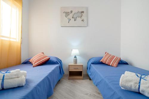 two beds in a room with blue sheets at Cambrils Turistic 3a in Cambrils