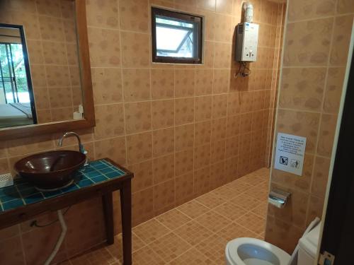 a bathroom with a sink and a toilet at Buffalo Bay Vacation Club in Ko Phayam
