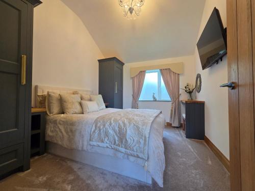 a bedroom with a bed and a window and a chandelier at Sunnie view lodge 2 bedroom in Lound