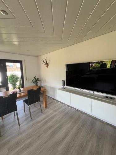 a living room with a large flat screen tv at Tannennest in Seewald