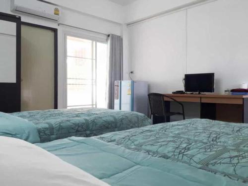a bedroom with two beds and a desk with a computer at Wanarom Resort in Ban Maklua Kao