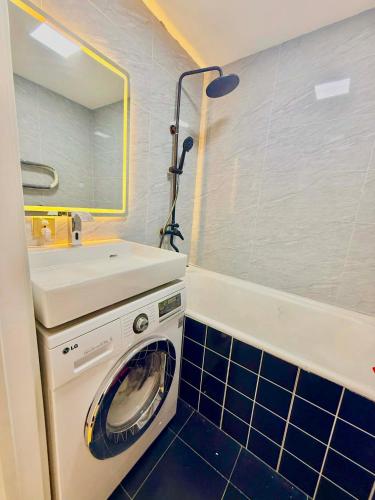 a washing machine in a bathroom with a sink at Yura Hostel in Darhan