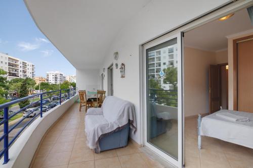 a balcony with a bed and a table at Rei Apartment in Quarteira