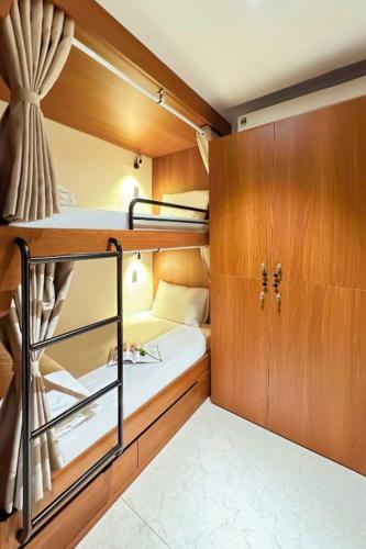 a small room with a bunk bed and wooden cabinets at Seaforest Hotel by Haviland in Danang