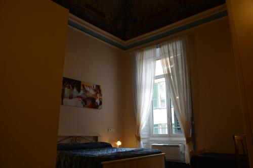 a bedroom with a bed and a window with curtains at Family Hotel Balbi in Genoa