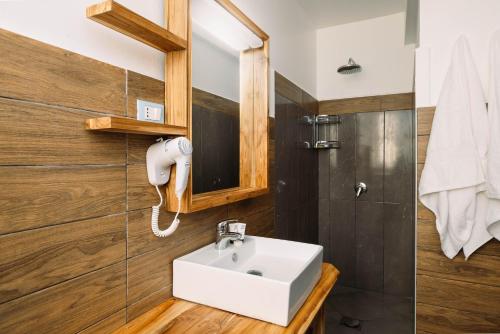 a bathroom with a white sink and wooden walls at Blackstone Beach Resort in Uroa