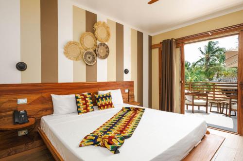a bedroom with a white bed with a phone on it at Blackstone Beach Resort in Uroa