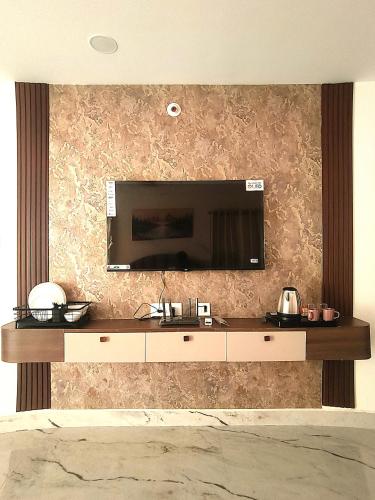 a living room with a television on a wall at Newly Launched Servostay Luxe Botique Hotel Near Miyapur Metro in Lingampalli