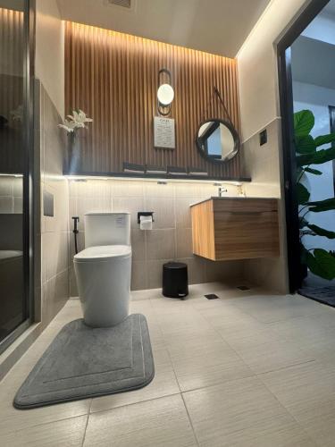 a bathroom with a toilet and a sink and a mirror at D Grey Pillows - 16th Floor One-Bedroom Condo Unit with Sea View in Pontud