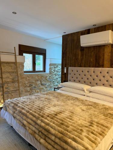 a bedroom with a large bed with a wooden wall at Casa Tramuntana in El Port de la Selva