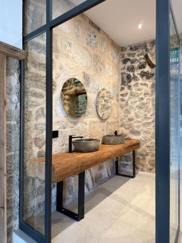 a stone bathroom with two sinks and a mirror at Casa Tramuntana in El Port de la Selva