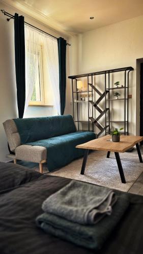 a living room with a green couch and a table at podZZamkem in Jaroslavice
