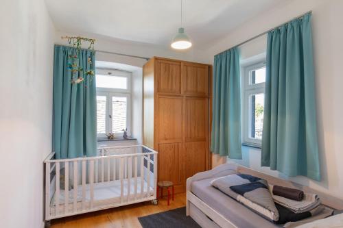 a baby room with a crib and green curtains at Eifel with Family in Thür