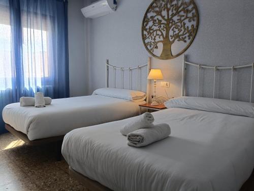 a bedroom with two beds and a tree mirror at Casa Rural Casa Juli in Arguedas