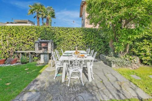 a white table and chairs in a garden at Casa Viola Losone for 8 - Happy Rentals in Losone