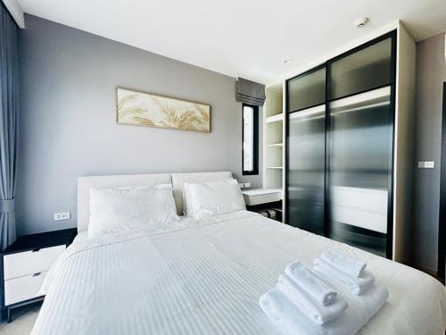 a bedroom with a white bed with towels on it at Legendary 2 Bdr Comfort in Bang Tao Beach