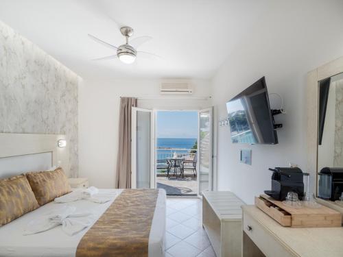 a bedroom with a bed and a view of the ocean at Pension Votsi in Votsi