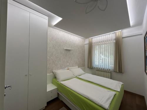 ein kleines Schlafzimmer mit einem Bett und einem Fenster in der Unterkunft Apartments Villa BEAUTY PORTOROŽ in Portorož