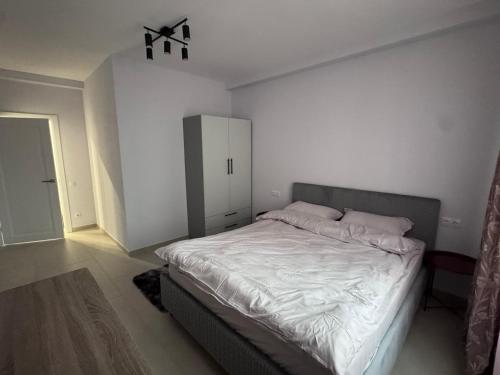 a bedroom with a white bed and a cabinet at Apart Hotel Balti 2 in Bălţi