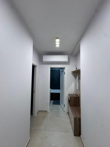 a hallway with a white wall and a hallway with a door at Apart Hotel Balti 2 in Bălţi