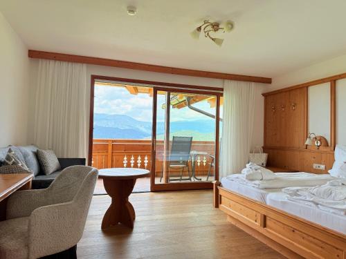 a hotel room with a bed and a balcony at Hotel Rosslaufhof in Castelrotto