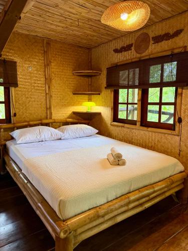 a bed with a pair of shoes sitting on it at Treehouses Yao Noi in Ko Yao Noi