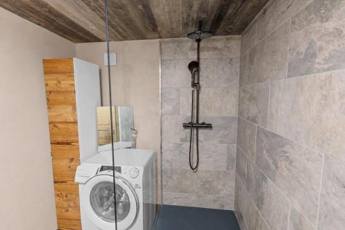 a bathroom with a washing machine in a shower at Studio chaleureux au coeur d'un chalet alpin in Zinal
