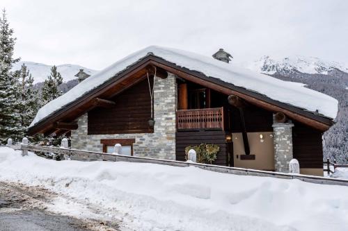 a log cabin with snow on the roof at Ca' De Sass in Pila