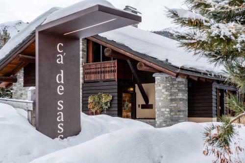 a sign for a guest house in the snow at Ca' De Sass in Pila