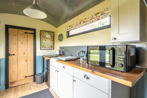 a kitchen with a counter top with a microwave at The Carriage in Matlock