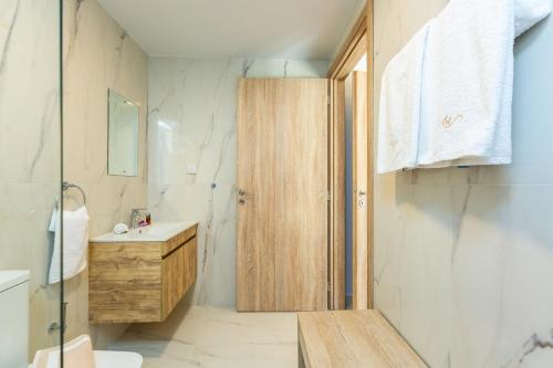a bathroom with a sink and a wooden door at Flower Village in Chania