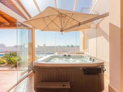 a hot tub in a room with an umbrella at Villa Evita Private Pool, Jacuzzi & Sea views in Adeje