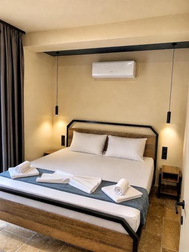 a bedroom with a bed with two towels on it at RCR The Stones in Flogita