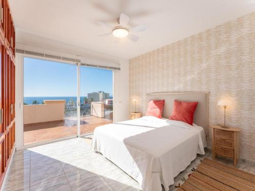 a bedroom with a bed and a large window at Villa Evita Private Pool, Jacuzzi & Sea views in Adeje