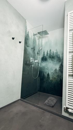 a bathroom with a shower with a forest mural on the wall at Hotel Garni Bergblick in Biberach bei Offenburg