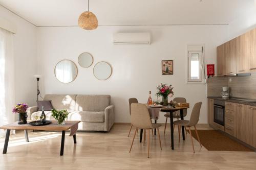 a living room with two tables and a couch at Filerimos Nest - Private Countyard in Pastida