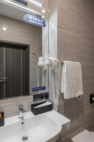 a bathroom with a sink and a mirror at Ribas Rooms Odesa in Odesa