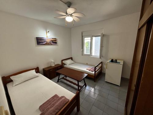 a room with two beds and a chair and a window at Stone Villa in Bečići