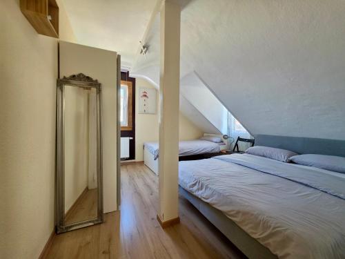 a bedroom with two beds and a stair case at Kamus in Baden-Baden