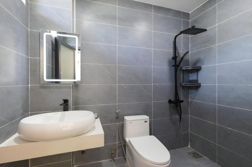 a bathroom with a toilet and a sink and a mirror at Happy House Villa Phu Quoc in Phú Quốc