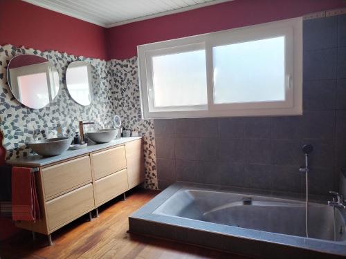 a bathroom with a tub and two sinks and two mirrors at Au Mas Saint Pierre - Chambres d'hotes de charme et gite in Pignans