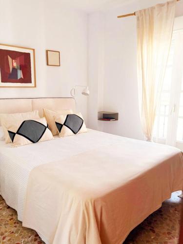 a bedroom with a large white bed with a window at La Duquesita - Ideal para escapada en pareja in Arcos de la Frontera
