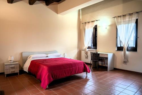 a bedroom with a bed with a red blanket at Tenute Sciara in Randazzo