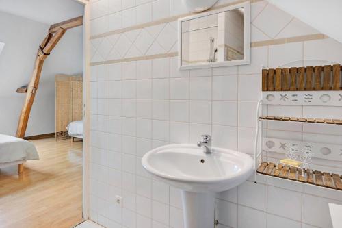 a white bathroom with a sink and a mirror at Le Bourg Joly in Rigny-Ussé
