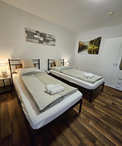 two beds in a room with wooden floors at Apartment "North Star" in Dinkelsbühl