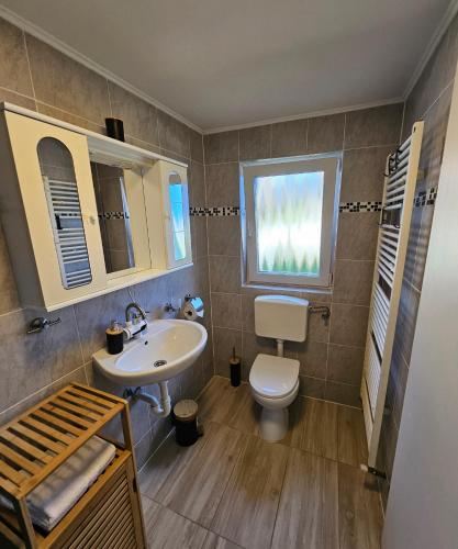 a bathroom with a sink and a toilet and a window at Apartment "North Star" in Dinkelsbühl